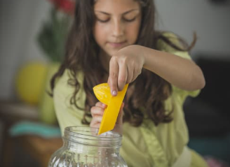 Child juicing lemon into pitcher
