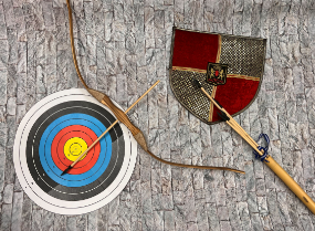 photo of paper target, wooden arrows, and colorful shield