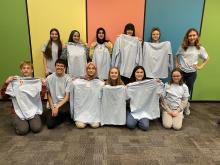 Image of teen advisory board members holding new t-shirts.
